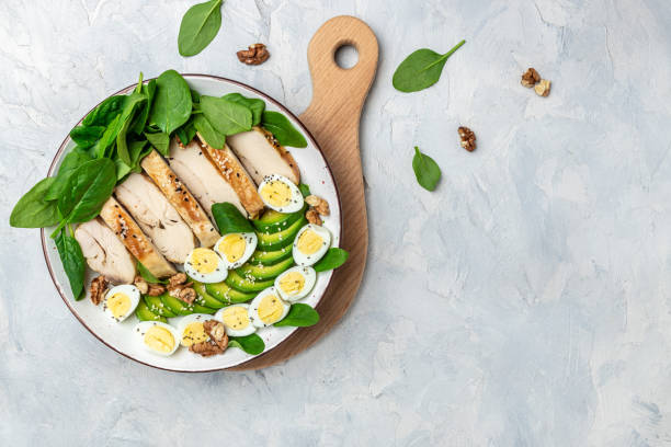 ketogenic diet food, chicken fillet, quail eggs, avocado, spinach, walnut. healthy meal concept on a gray background, top view - chicken breast chicken grilled chicken protein imagens e fotografias de stock