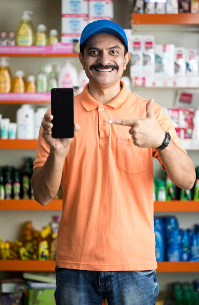 istock Male owner showing phone in store 1442397138