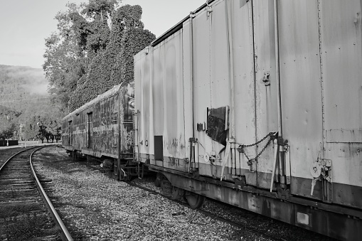 A grayscale shot of a wagon of a train on the railway track