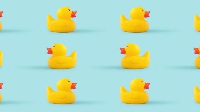 Closeup of tiny duck toys moving against a blue background