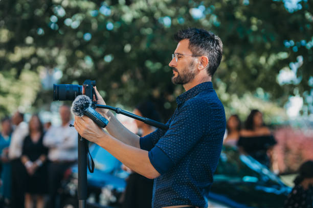 istock Photographer taking a video in a park 1442404117