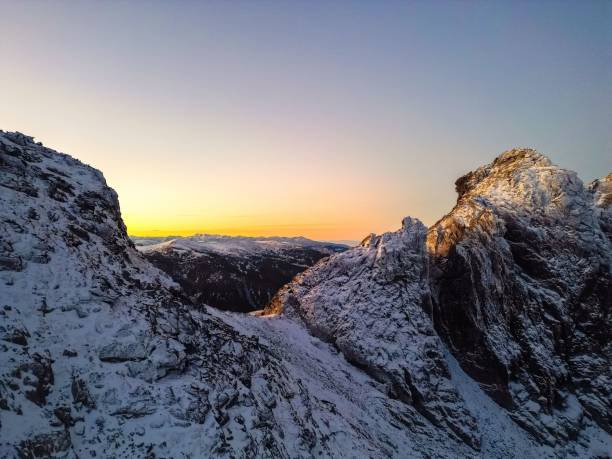 istock Beautiful sunset over a rocky snow-covered hill 1442406310