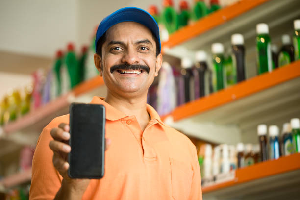 istock Male owner showing phone in store 1442407969
