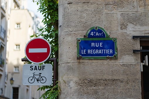 A blue street sign with the Rue Le Regrattier street name and a red \
