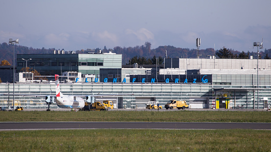 Graz, Austria – December 31, 2020: Austrian regional aircraft parked in front of terminal at airport Graz and waiting for passengers