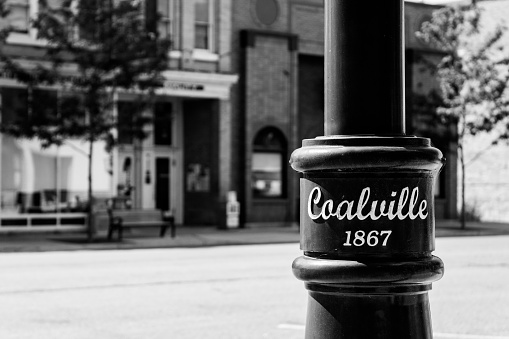 Coalville, United States – September 06, 2016: A grayscale shot of a city light pole on the quiet weekend streets of Coalville, UT