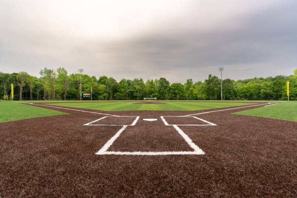 Scenic view of a baseball field with artificial grass in cloudy sky background A scenic view of a baseball field with artificial grass in cloudy sky background artifical grass stock pictures, royalty-free photos & images
