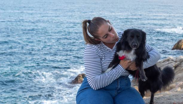 istock Woman and dog playing on the beach 1442412876