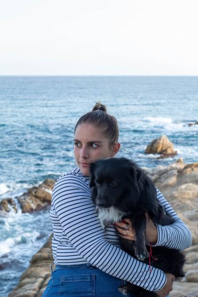 istock Woman and dog playing on the beach 1442412893