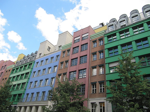 The facade of colorful apartment buildings against a blue cloudy sky