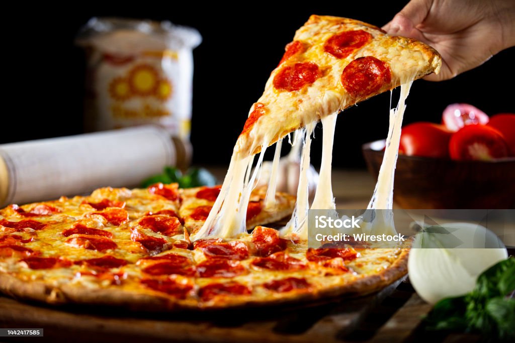 Persona recibiendo un pedazo de pizza de pepperoni con queso - Foto de stock de Pizza libre de derechos