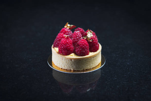 istock Selective of a small round cake with raspberries on a gray surface 1442420308