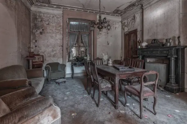 Photo of Dining room of an abandoned house with a table and chairs