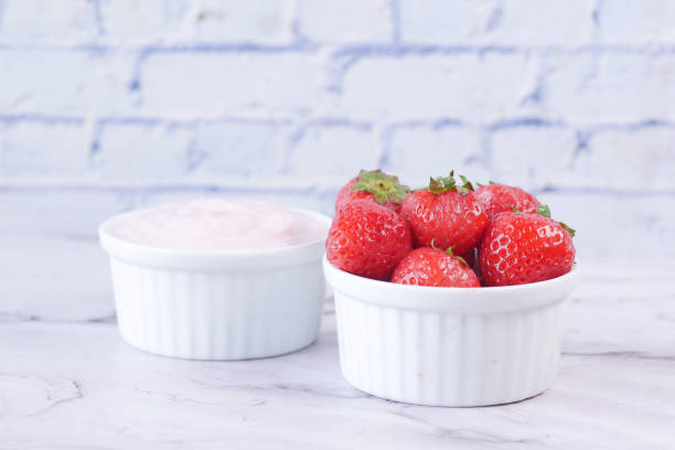 istock Yogurt and strawberry in a bowl on white 1442421872