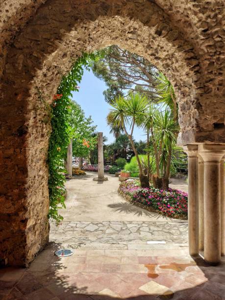istock Old arch gate with small pillars leading to a beautiful garden on a sunny day 1442422086