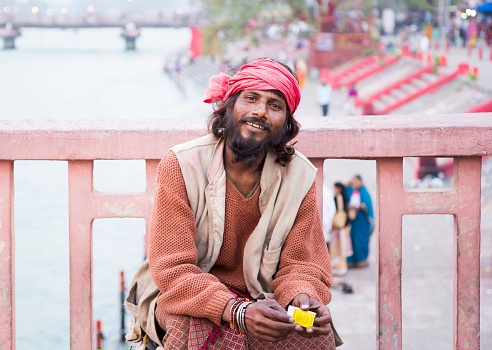 Haridwar, India – March 23, 2014: The portrait of Sadhu man on the bridge of the Ganges river, close-up