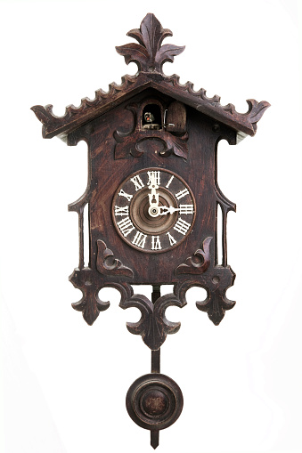 A vertical shot of a black forest cuckoo clock on white background