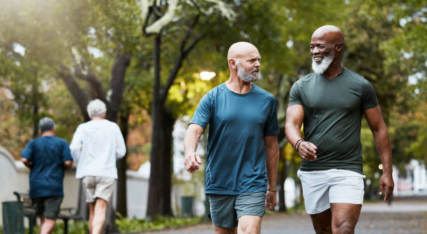 istock Fitness, exercise and men walking together at community park while talking and doing cardio training outdoor in nature. Diversity, friends and senior man and accountability partner on a wellness walk 1442429259