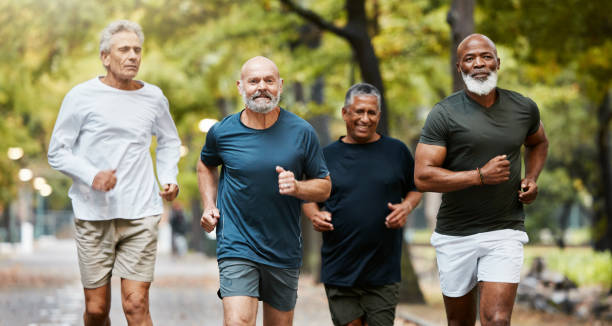 фитнес, бег и группа пожилых мужчин, выполняющих упражнения, тренировки и тренировки вместе в парке в выходные дни. природа, дружба и пожилы� - distance running фотографии стоковые фото и изображения