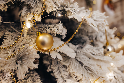 Close-up shot of Christmas ornament and lights hanging on Christmas tree. No people