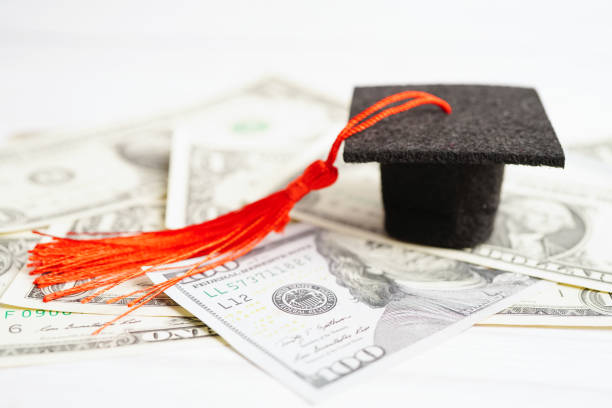 istock Graduation gap hat on US dollar banknotes money, Education study fee learning teach concept. 1442436610