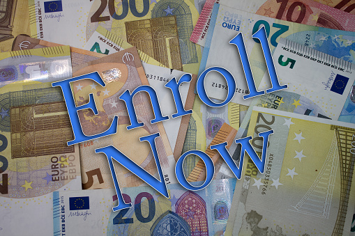 Enroll Now word with money. Paper currency background with different banknotes.