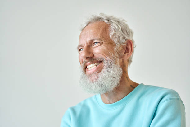 istock Laughing bearded senior older man isolated standing at white wall. 1442438012