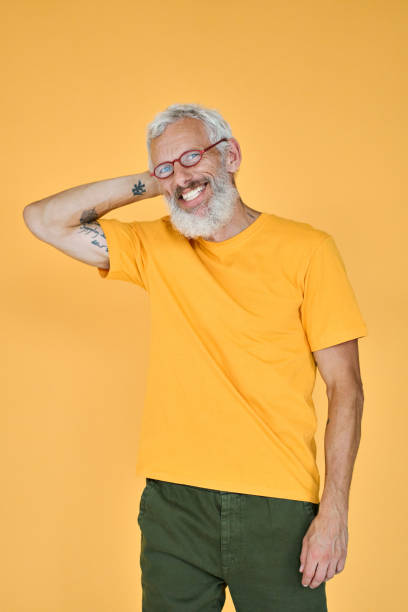 istock Smiling older bearded hipster man standing isolated on yellow background. 1442438040