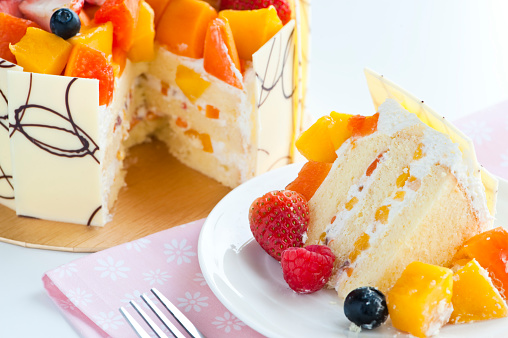 close up of slice of cream cake with fruits, christmas cake