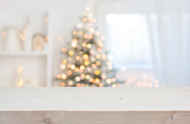Wooden table in front of abstract blurred Christmas decorations background stock photo