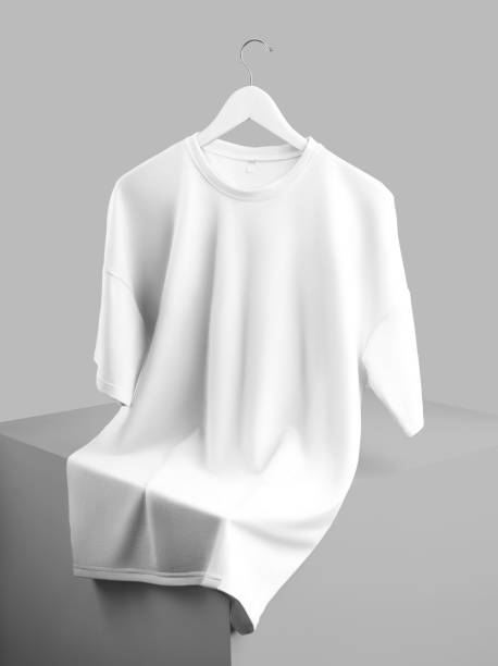 istock Mockup of an oversized white t-shirt hanging on a hanger, laid out over a cube, front view, isolated on background. 1442440267