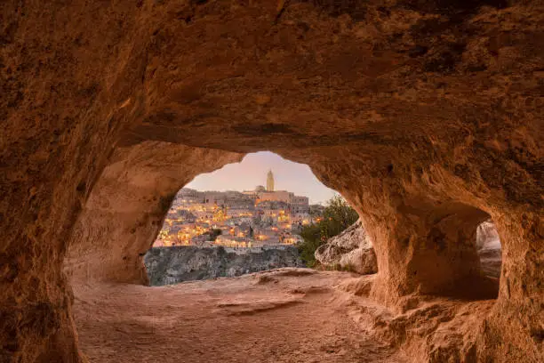 Matera, Italy as seen from within an ancient cave at dusk.