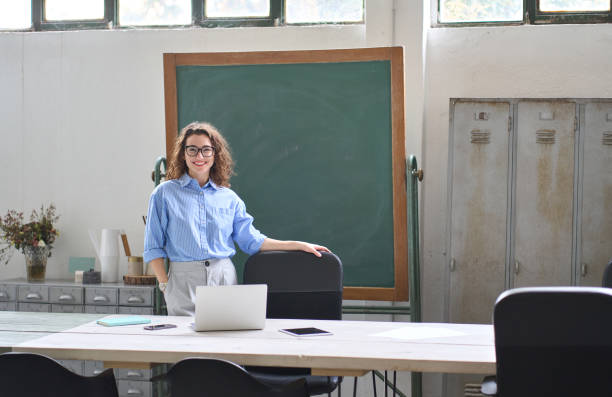 joven y feliz mujer de negocios entrenadora o maestra de pie en el escritorio de la oficina. - master of business administration fotografías e imágenes de stock