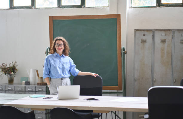 молодая счастливая бизнес-леди тренер или учитель стоит за партой в офисе. - social housing audio стоковые фото и изображения