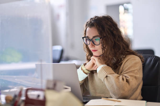 istock Young professional woman using laptop watching online webinar at work. 1442442055