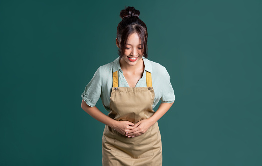 portrait of Asian woman wearing apron on green background