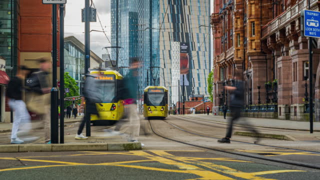 Time lapse of Moving Tram and Bus with Crowded Commuter People and Tourist walking and traveling around Manchester Downtown District