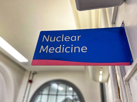 Color image depicting a sign saying ‘nuclear medicine’ in a hospital corridor.