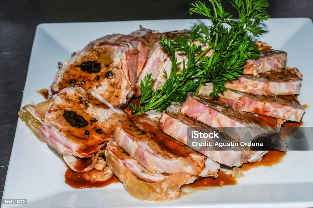 Rolled meatloaf with sauce, presented in slices on a white plate. Rolled meatloaf with sauce, presented in slices on a white plate Color Image Stock Photo
