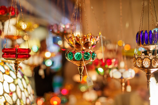 Christmas candle holders ornated with gems hanging on golden chains on market stall