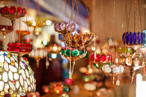 Ornate Christmas candle holders hanging on golden chains on market stall