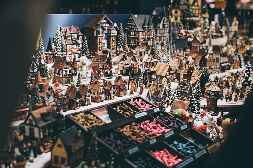 Decorations in shape of little houses and incense sticks on Christmas market stall