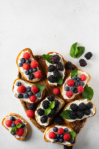 Berries toast breakfast, healthy food on white background, top view, copy space, vertical