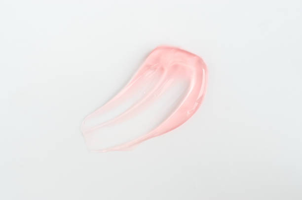 Rose cosmetic gel (face mask, cream, shampoo, lip gloss, hair gel) texture. Transparent skincare cream blob smear on white background. Cosmetic product swatch close-up, selective focus. gel cosmético rosa (mascarilla facial, crema, champú, brillo labial, gel para el cabello) textura. mancha de crema transparente para el cuidado de la piel sobre fondo blanco. muestra de primer plano del producto cosmético, enfoque selectivo.