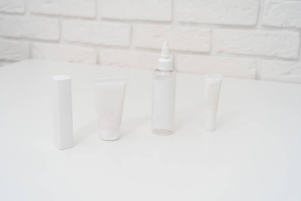 istock Packing tubes on table and white brick wall background. Cosmetics, beauty and spa concept 1442450316