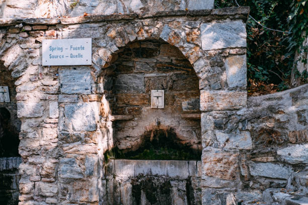 Weathered stone arch on rustic wall with intricate patterns.