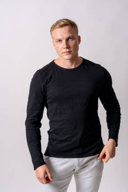 istock Attractive blonde german model in a black sweater on a white background, looking at the camera seriously 1442453874