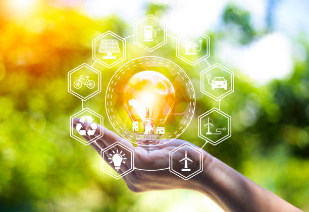 istock green energy concept help reduce global warming.Hand holding natural background light bulb on green leaf with clean energy icon around it. Carbon dioxide emission in industry zero carbon concept. 1442470479