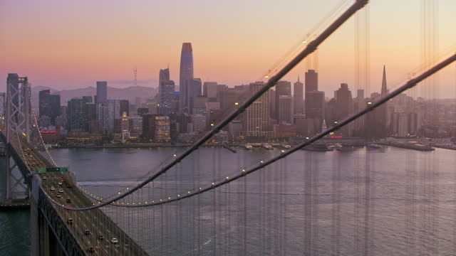 AERIAL Along the San Francisco-Oakland Bay Bridge in San Francisco at dusk