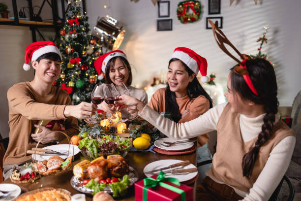 Asian people group Celebrate Christmas with red wine at home at night stock photo